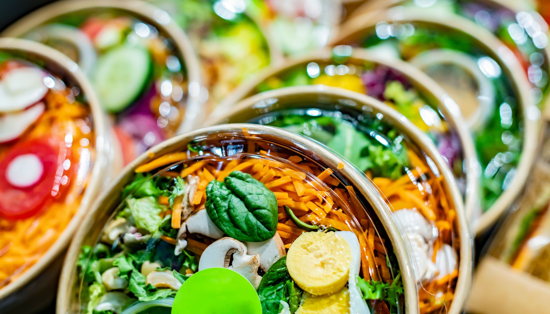 Saladas de vegetais exibidas em um refrigerador comercial